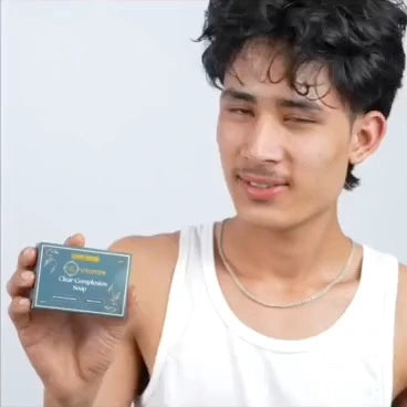 Person holding a clear complexion soap with a plain background
