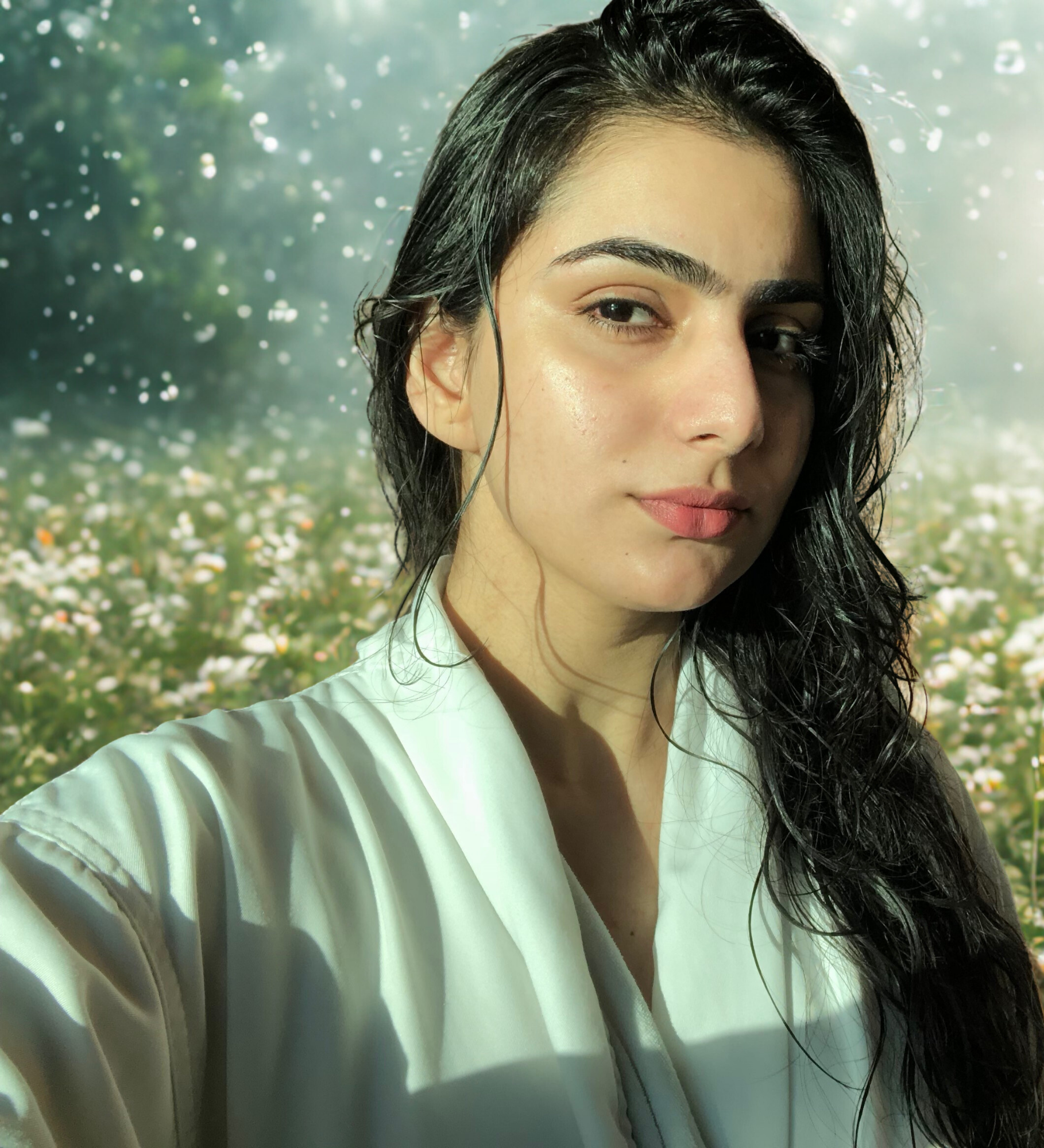 Woman in a white outfit with a blurred natural background